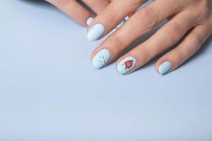 mãos femininas com manicure de neve de inverno com adesivos sob um top fosco foto