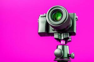 câmera profissional em um tripé, em um fundo rosa. gravar vídeos e fotos para o seu blog ou relatório.