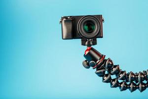 câmera profissional em um tripé, sobre um fundo azul. gravar vídeos e fotos para o seu blog ou relatório.
