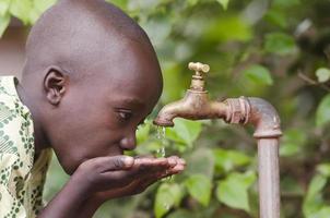 menino africano do congo precisando de água potável foto