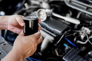 fechar o filtro de óleo do carro a motor e uma mudança de homem no conceito de serviço da sala de máquinas foto