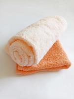 toalha enrolada bege e toalha laranja pequena foto