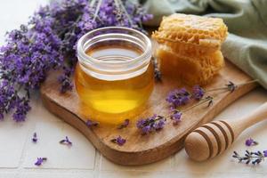 jarra com mel e flores frescas de lavanda foto