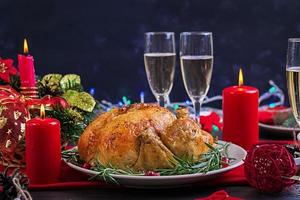 peru assado. ceia de Natal. a mesa de natal é servida com um peru, decorado com enfeites brilhantes e velas. frango frito, mesa. jantar em família. foto