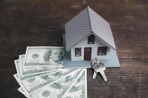 hipoteca de propriedade de casa com dinheiro em dinheiro nota de dólar na mesa conceito de finanças empresariais, economizando para comprar casa, empréstimo de investimento, moeda americana, propriedade de venda, pagamento bancário, venda de aluguel de imóveis foto