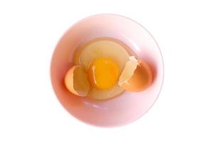 casca de ovo e ovos abertos em uma tigela rosa .top view closeup. foto