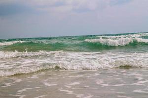 onda suave branca na praia tropical vazia e mar azul com céu azul foto