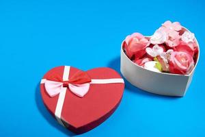 um cartão postal de uma caixa em forma de coração e rosebuds.valentine's day concept foto