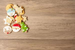 feliz natal com biscoitos caseiros no fundo da mesa de madeira. natal, festa, feriado e feliz ano novo conceito foto