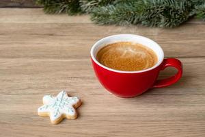 feliz natal com biscoitos caseiros e xícara de café no fundo da mesa de madeira. véspera de natal, festa, feriado e feliz ano novo conceito foto