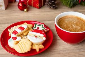 feliz natal com biscoitos caseiros e xícara de café no fundo da mesa de madeira. véspera de natal, festa, feriado e feliz ano novo conceito foto