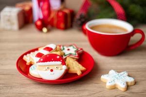 feliz natal com biscoitos caseiros e xícara de café no fundo da mesa de madeira. véspera de natal, festa, feriado e feliz ano novo conceito foto