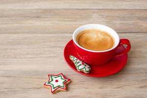 feliz natal com biscoitos caseiros e xícara de café no fundo da mesa de madeira. véspera de natal, festa, feriado e feliz ano novo conceito foto