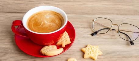 feliz natal com biscoitos caseiros e xícara de café no fundo da mesa de madeira. véspera de natal, festa, feriado e feliz ano novo conceito foto