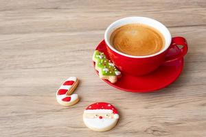 feliz natal com biscoitos caseiros e xícara de café no fundo da mesa de madeira. véspera de natal, festa, feriado e feliz ano novo conceito foto