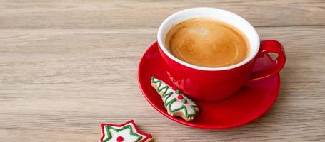 feliz natal com biscoitos caseiros e xícara de café no fundo da mesa de madeira. véspera de natal, festa, feriado e feliz ano novo conceito foto