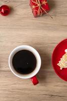 feliz natal com biscoitos caseiros e xícara de café no fundo da mesa de madeira. véspera de natal, festa, feriado e feliz ano novo conceito foto