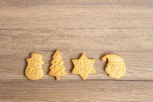 feliz natal com biscoitos caseiros no fundo da mesa de madeira. natal, festa, feriado e feliz ano novo conceito foto