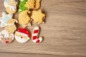 feliz natal com biscoitos caseiros no fundo da mesa de madeira. natal, festa, feriado e feliz ano novo conceito foto