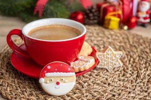 feliz natal com biscoitos caseiros e xícara de café no fundo da mesa de madeira. véspera de natal, festa, feriado e feliz ano novo conceito foto