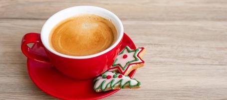 feliz natal com biscoitos caseiros e xícara de café no fundo da mesa de madeira. véspera de natal, festa, feriado e feliz ano novo conceito foto