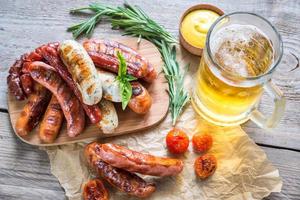 salsichas grelhadas com copo de cerveja foto