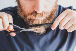 homem cortando bigode e barba em casa foto