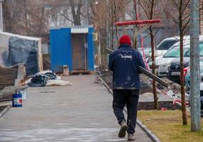 dnepropetrovsk, ucrânia - 02.10.2022 um homem carrega uma viga de ferro para um canteiro de obras. foto