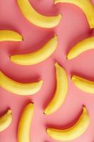 bananas amarelas espalhadas no fundo rosa com padrão de textura foto
