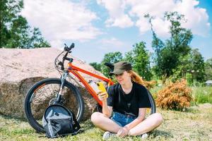 jovem mulher atraente está descansando após o passeio de bicicleta. estilo de vida ativo, esportes foto