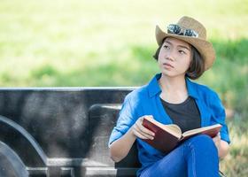 mulher usa chapéu e lê o livro na caminhonete foto