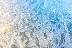 janela de inverno congelado com textura de padrão de geada de gelo brilhante. símbolo de maravilha de natal, abstrato. extremo norte de baixa temperatura, neve de gelo natural em vidro gelado, clima frio de inverno ao ar livre. foto