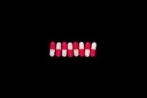 pílulas médicas isoladas em fundo preto foto