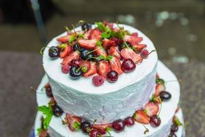 bolo de casamento branco decorado por flores frutas foto