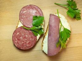 sanduíche com salame, carne, queijo derretido e salsa. comida caseira. comida com pressa. foto