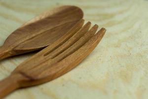 close-up de colher de pau e garfo na placa de madeira foto