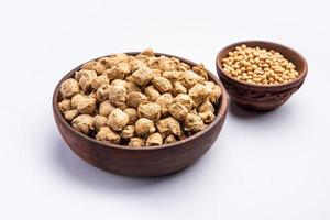 glycine max ou grãos de soja ou pedaços de soja crua. servido em uma tigela ou como uma pilha. foco seletivo foto