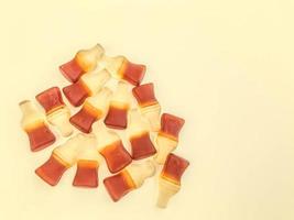 marmelada é colocada em um fundo amarelo, brilhante e fosco. doces de gelatina em forma de garrafas com limonada. doces apetitosos, decoração de bolos e doces foto