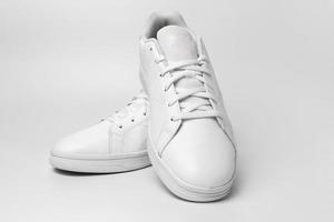 novo par de tênis branco isolado no fundo branco para cortar. par de sapatos esportivos para maquete. sapatos casuais de esportes elegantes na moda. foto