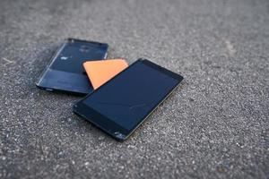 smartphone danificado com tela de toque quebrada no asfalto foto