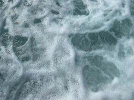 belo mar com ondas espirrando água azul clara e morna em um resort do sul do país oriental tropical quente. fundo, textura foto