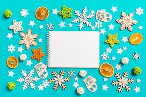 vista superior do notebook sobre fundo azul com brinquedos e decorações de ano novo. conceito de tempo de natal foto