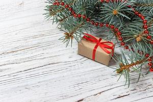 presentes de natal ou ano novo embrulhados em papel colorido natural e decorados com barbante de natal tradicional e galhos de abeto em um fundo branco foto