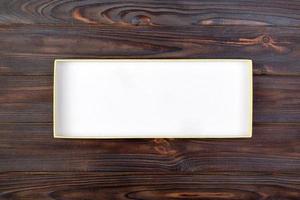caixa de papelão branca aberta em uma mesa escura, fundo de madeira. vista do topo foto