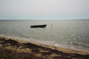 um velho barco de pesca, parado na água esperando o pescador. foto