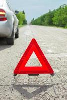 triângulo vermelho de um carro na estrada. avaria do carro com mau tempo foto