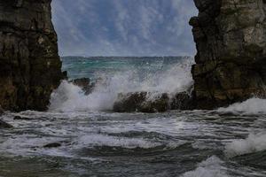 ondas quebrando entre pilares de rocha foto