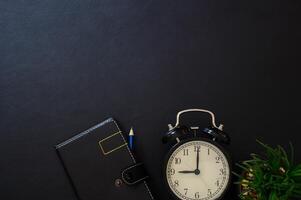 caderno e relógio na mesa, vista de cima foto