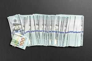 vista superior de mentir notas de 100 dólares em uma linha sobre fundo colorido. close-up do conceito de economia de dinheiro foto