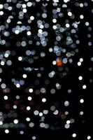 luzes brancas bokeh em fundo preto, desfocadas e desfocadas muitas luzes redondas em fundo foto